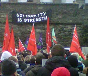 Anarchist banner hangs from city walls in Derry during N30 strike rally